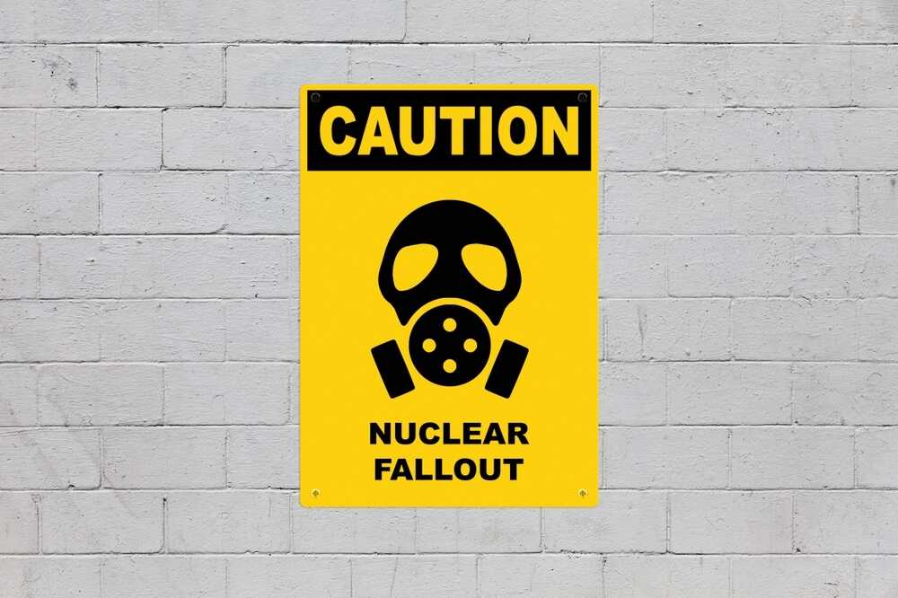 Yellow,warning,sign,screwed,to,a,brick,wall,to,warn